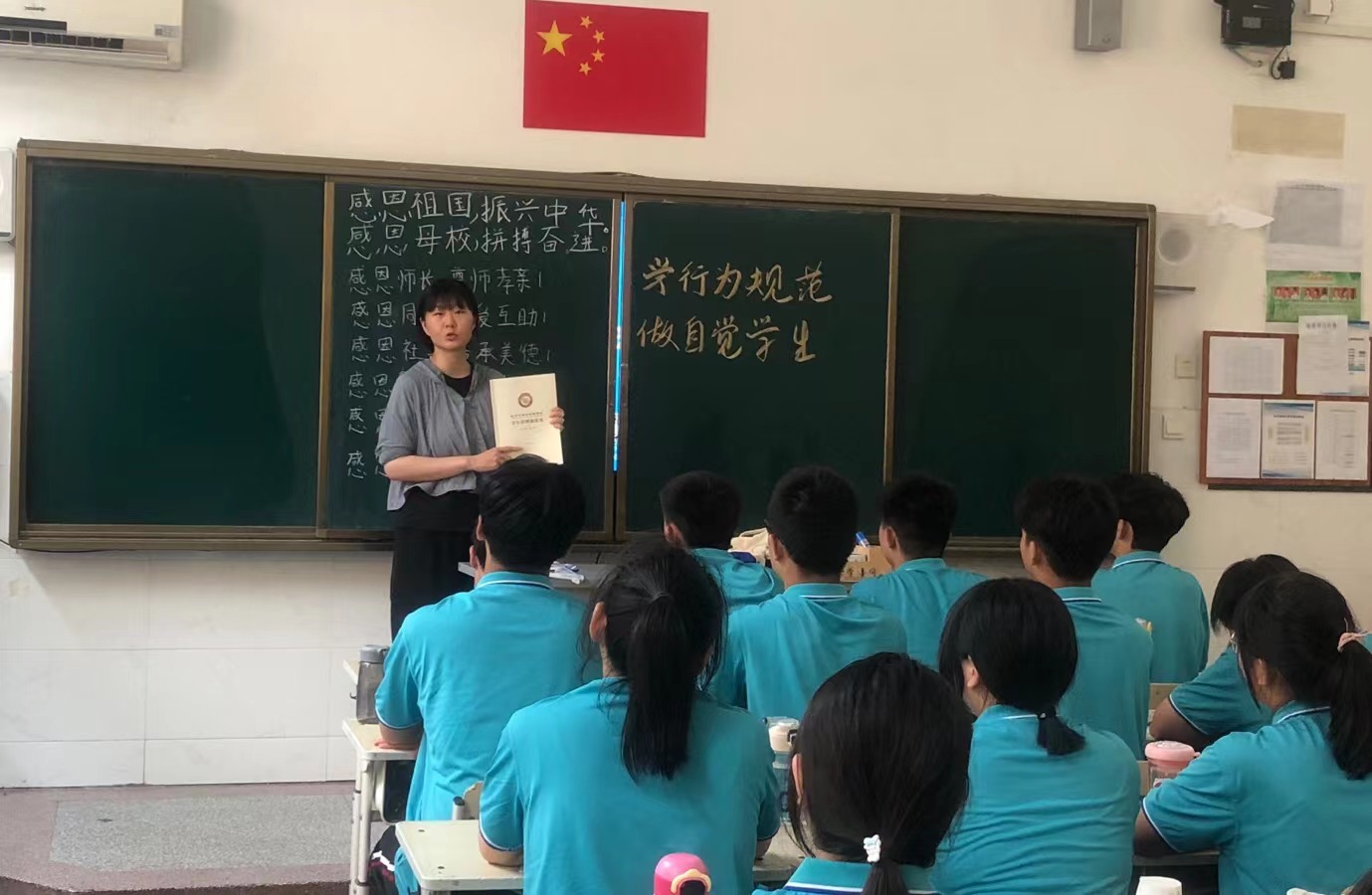 班主任向学生展示“学生管理制度集”
